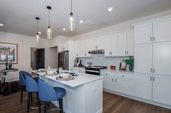 A modern kitchen with a dining table and chairs.