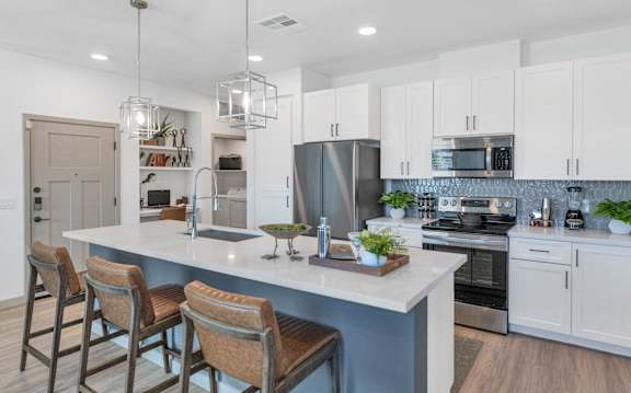 A modern kitchen with a bar area and stools.