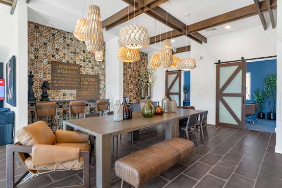 A dining room with a table and chairs and a wallpapered wall.