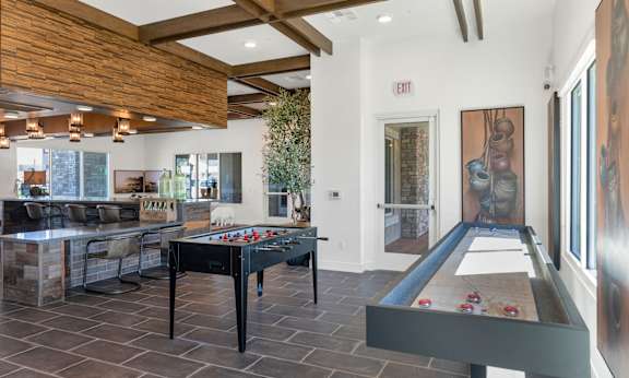 A pool table with a black cloth and red balls is in the center of a room with a wooden ceiling and a door marked "EXIT".