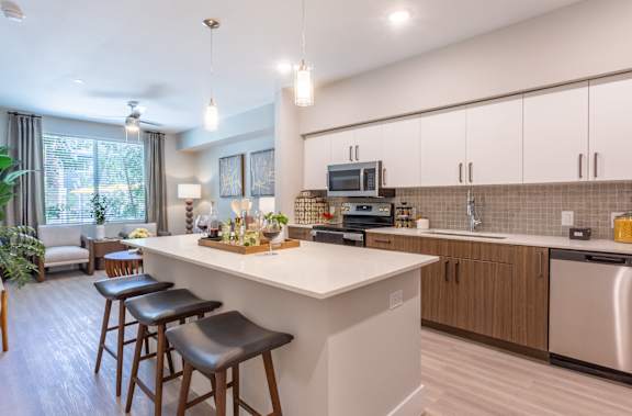 A modern kitchen with a bar area and stools.