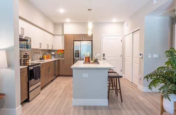 A modern kitchen with wooden cabinets and a central island.