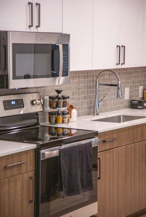 A kitchen with a stove, microwave, and oven.