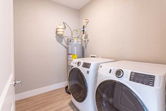 Two front load washing machines in a laundry room.