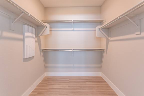 A white wall with a shelf and a white radiator on it.