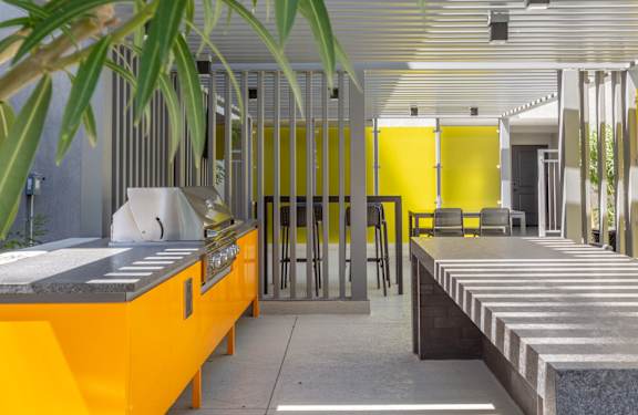A modern kitchen with yellow cabinets and a large island.