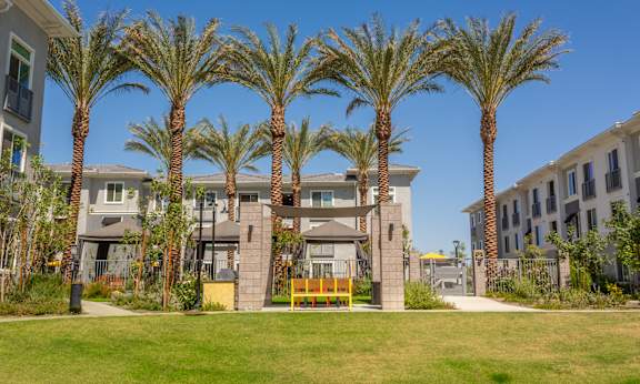 A row of palm trees in front of a building.