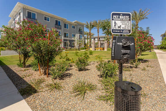 A sign in front of a building instructs to leash and pick up after pets.
