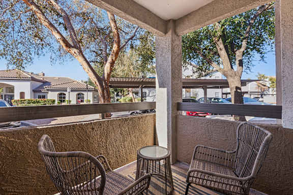 Two chairs and a table are on a patio.