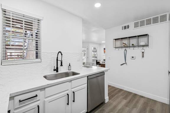 A modern kitchen with a white countertop and stainless steel appliances.