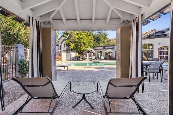 Two chairs and a table are on a patio.