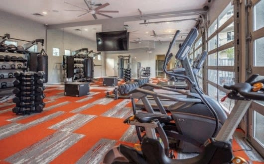 a gym with weights and cardio machines and a tv at Inspiration Apartments, Cottonwood, AZ, 86326