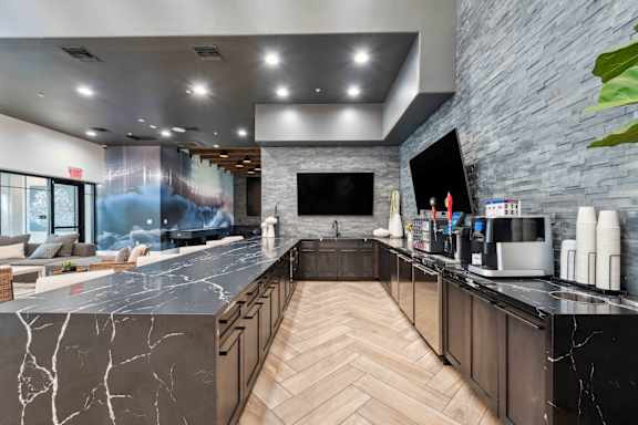 A modern kitchen with a marble countertop and wooden cabinets. at The Laurel Apartments, Arizona, 85286
