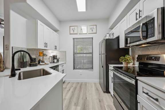 A modern kitchen with black appliances and white cabinets. at Lazo Apartment Homes, Chandler, AZ 85225