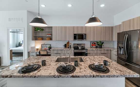 A kitchen with a granite countertop and stainless steel appliances.at Marketside Villas at Verrado, Arizona, 85396