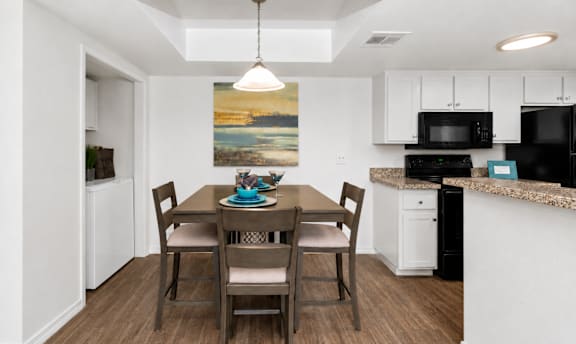 A dining room with a table set for four.