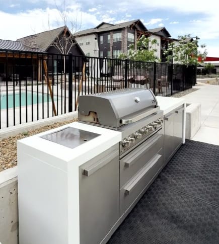 A modern outdoor kitchen with a built-in grill and sink.