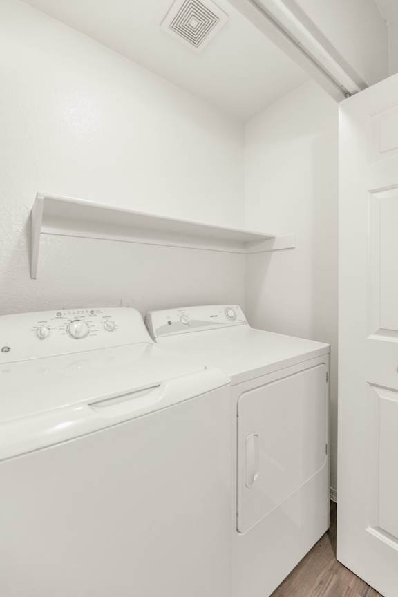 a white washer and dryer in a white room with a white door