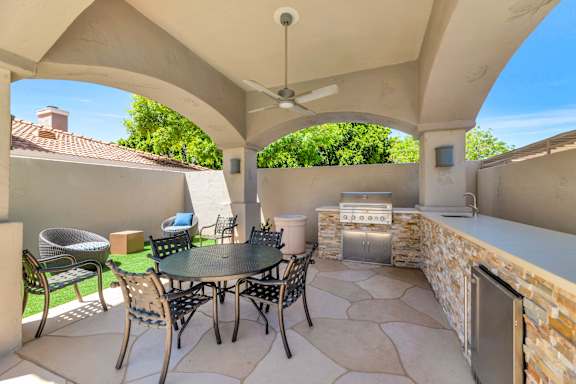 the outdoor patio has a grill and a table with chairs