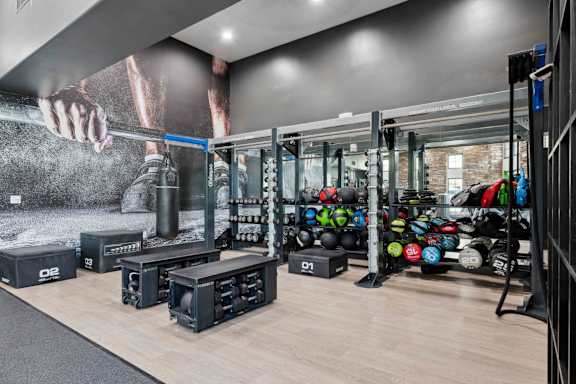 A gym with a variety of equipment including weights and weight racks. at The Laurel Apartments, Chandler, AZ