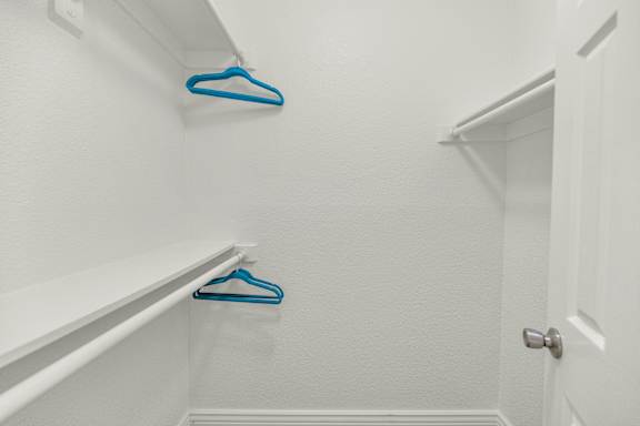 Two blue hangers are on the white wall at Urban WalkApartments on 6th Avenue, Arizona