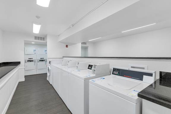 A row of white washing machines in a laundromat at Urban WalkApartments on 6th Avenue, Phoenix, AZ