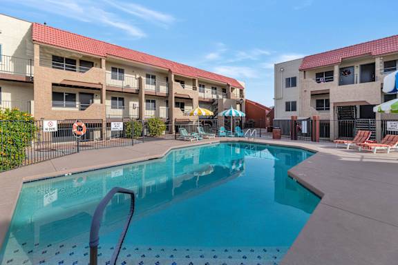 A swimming pool in front of apartment buildings at Urban WalkApartments on 6th Avenue, Phoenix, AZ