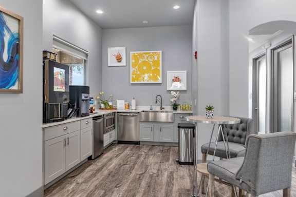 A modern kitchen with a grey chair and a table.