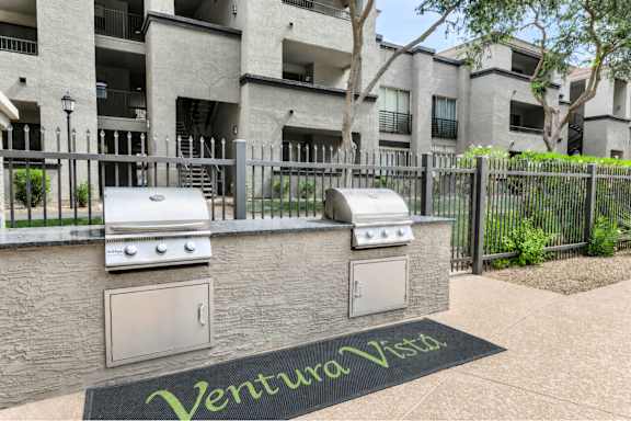 A black mat with the word Ventura Vista on it in front of a building.