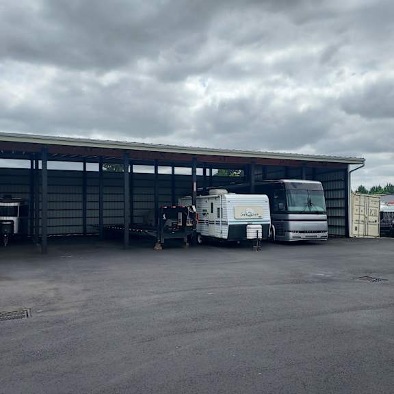 A caravan is parked in front of a large building.