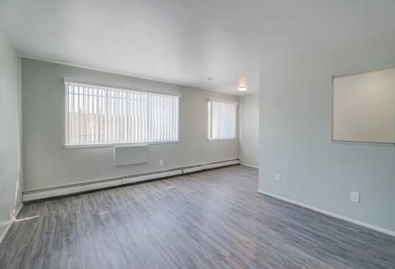 an empty living room with two windows