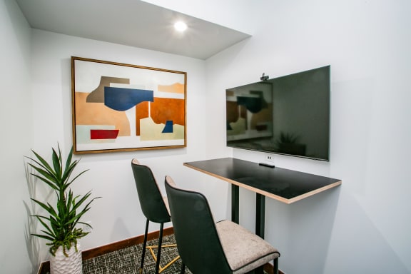 a dining room with a table and chairs and a tv on the wall
