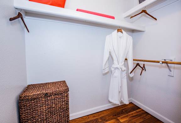 A white robe is hanging on a rack in a room.