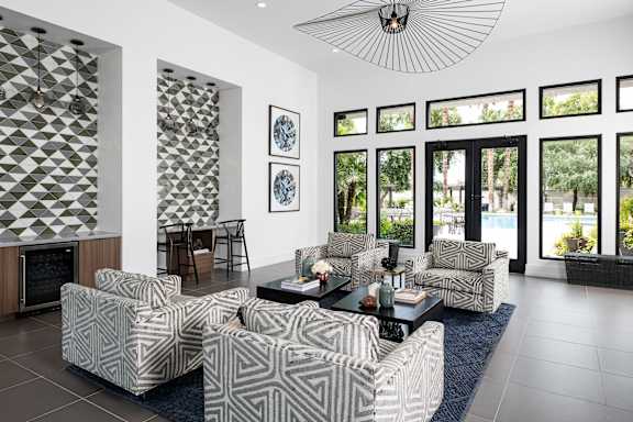 A living room with a patterned couch and a fan.