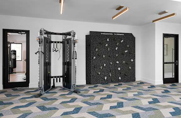 A gym with a climbing wall and a mirror.
