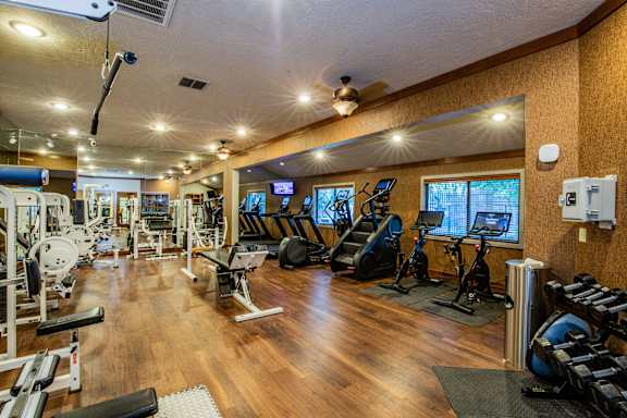 A well-equipped gym with a variety of exercise machines and weights.