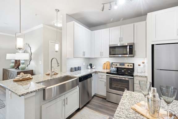 A modern kitchen with stainless steel appliances and white cabinets.