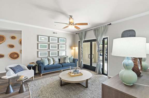 A living room with a blue couch and a white chair.