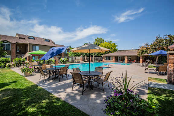 A poolside area with a table and chairs.