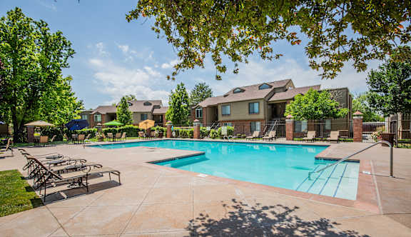 A large swimming pool surrounded by lounge chairs and umbrellas.