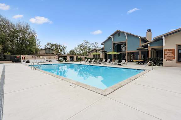 A large swimming pool in front of a house.