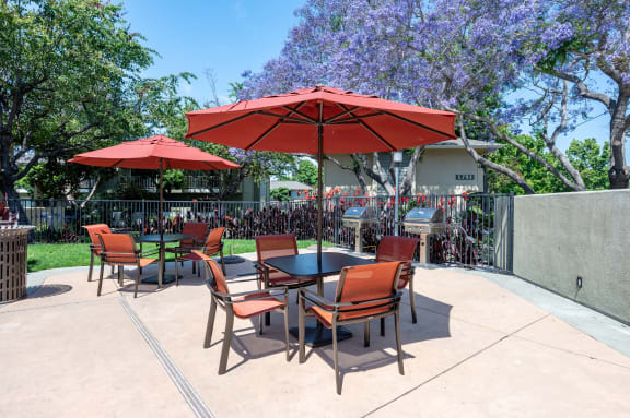 a patio with tables and chairs and umbrellas