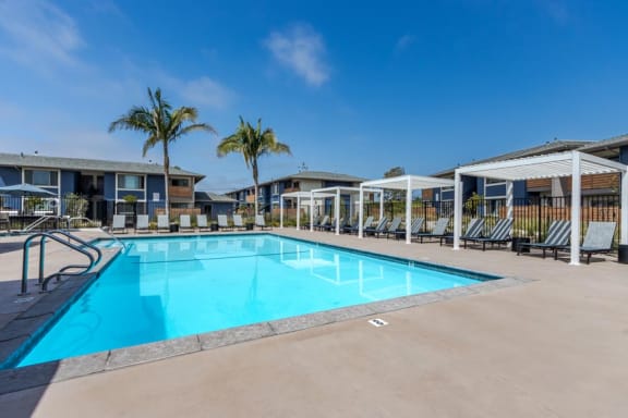 a swimming pool with palm trees in front of a building
