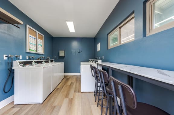 a laundry room with a bar top and chairs