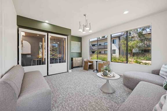 A living room with grey couches and a grey carpet.