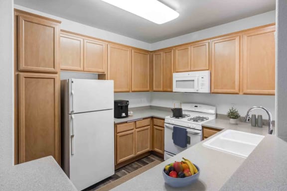 a kitchen with white appliances and wooden cabinets