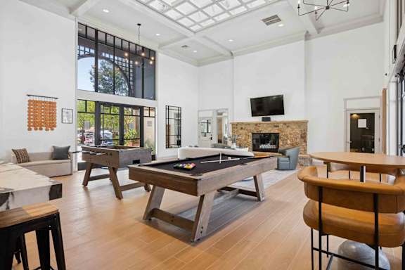 A room with a pool table and a fireplace.