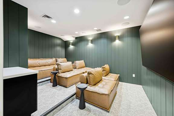 A living room with a tan couch and a black coffee table.