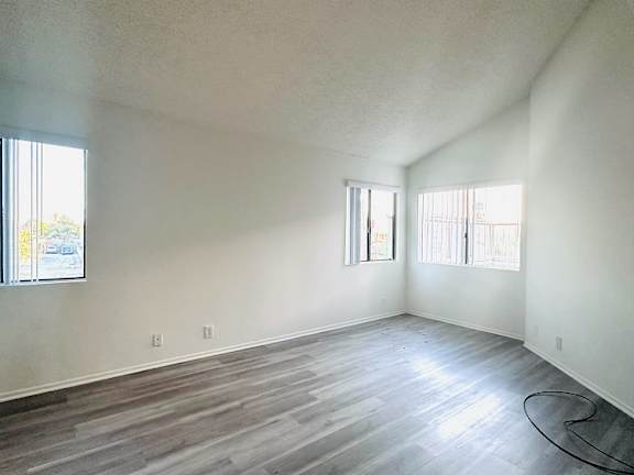 A room with a window and a wooden floor.