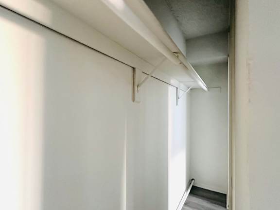 A white wall with a doorway leading to another room.